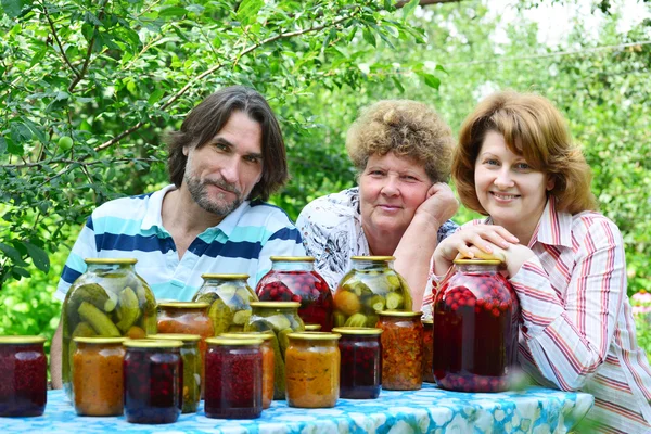 Семья с домашними консервированными овощами на природе — стоковое фото
