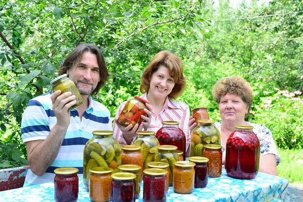 Familie met zelfgemaakte ingeblikte groenten op aard Rechtenvrije Stockfoto's