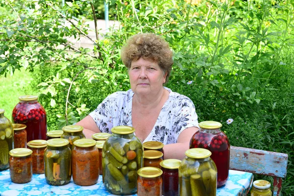 Reife Hausfrau mit Konserven für den Winter — Stockfoto