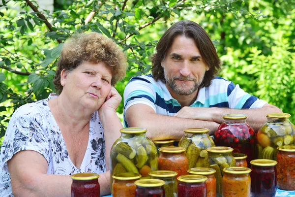 Femme et son fils à la table avec des légumes en conserve — Photo