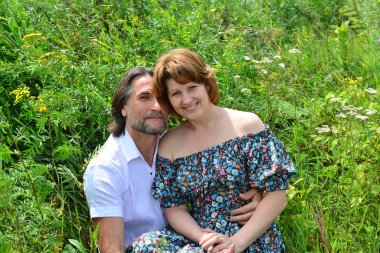 sevgi dolu çift yaz aylarında çim üzerinde oturan