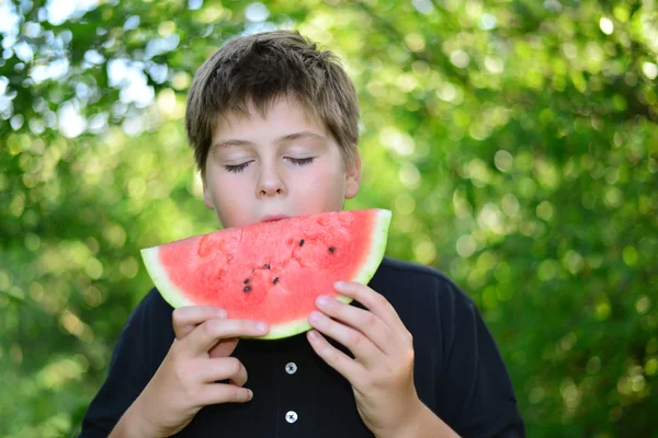 Teen boy eating watermelon in nature — Stock Photo, Image