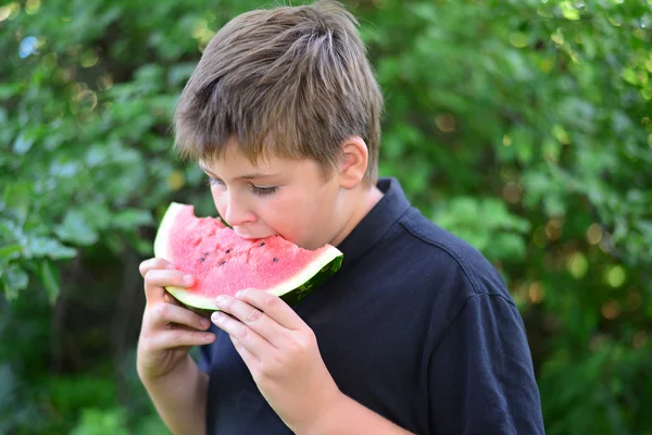 Teen boy eating watermelon in nature — Stock Photo, Image