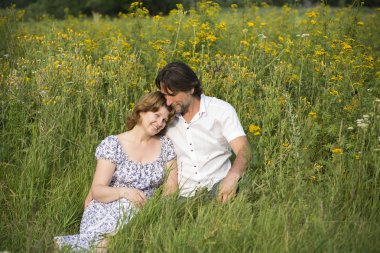 Çift bir çayır üzerinde rahatlatıcı sevgi dolu