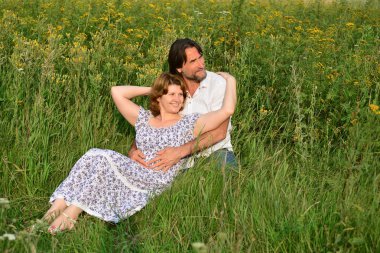 Çift bir çayır üzerinde rahatlatıcı sevgi dolu