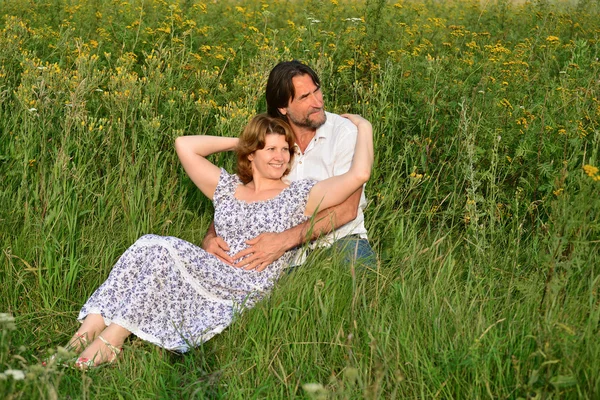 Çift bir çayır üzerinde rahatlatıcı sevgi dolu