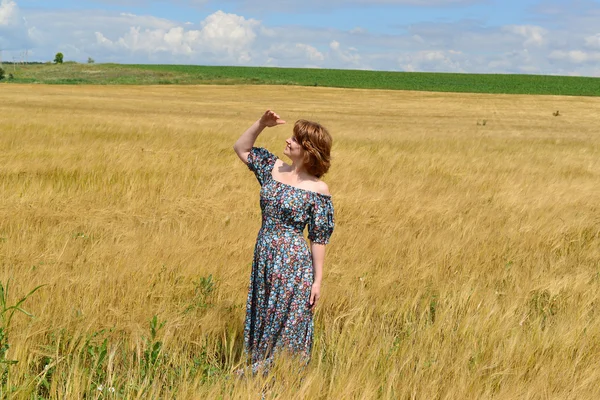 Donna in maxi abito in piedi sul campo di segale — Foto Stock