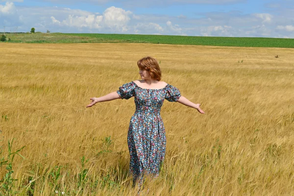 Mulher em maxi vestido de pé no campo de centeio — Fotografia de Stock