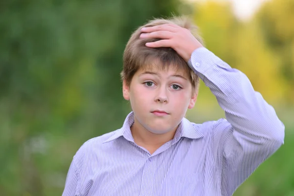 Förvånad pojke håller händerna bakom huvudet — Stockfoto