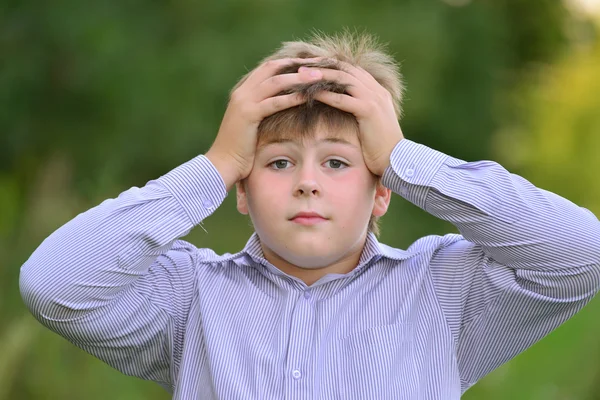 Förvånad pojke håller händerna bakom huvudet — Stockfoto