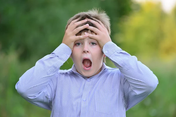 Erstaunter Junge hält seine Hände hinter dem Kopf — Stockfoto