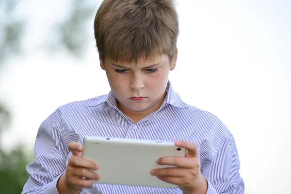 Adolescente menino com tablet computador na natureza — Fotografia de Stock