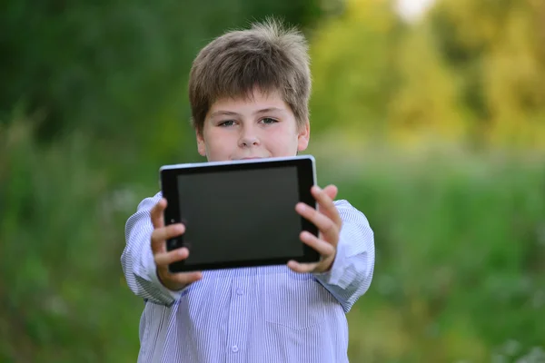 Dospívající chlapec s počítačem tablet v přírodě — Stock fotografie