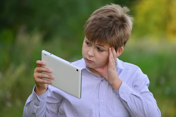 Tiener jongen met tablet pc op aard — Stockfoto