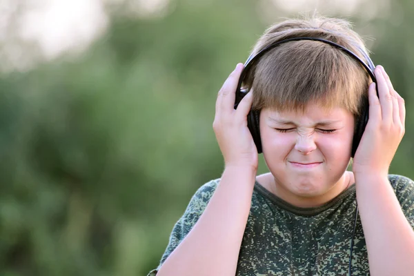 Niño escuchando música con auriculares — Foto de Stock