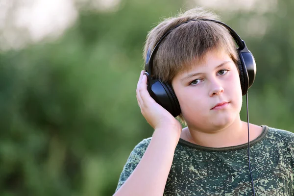 Niño escuchando música con auriculares — Foto de Stock