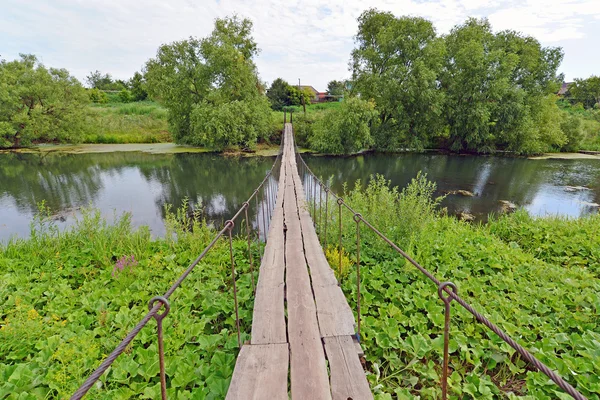 Ponte pedonal pendurada do outro lado do rio — Fotografia de Stock