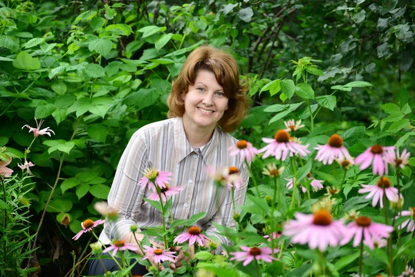 Bella donna si prende cura dietro le piante in giardino — Foto Stock