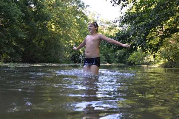 Мальчик-подросток плавает в реке летом — стоковое фото