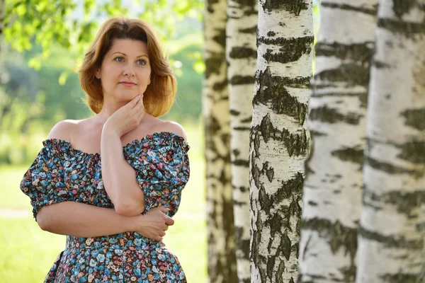 Woman in a dress with open shoulders is about Birch — Stock Photo, Image