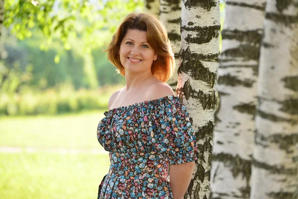 Woman in a dress with open shoulders is about Birch — Stock Photo, Image