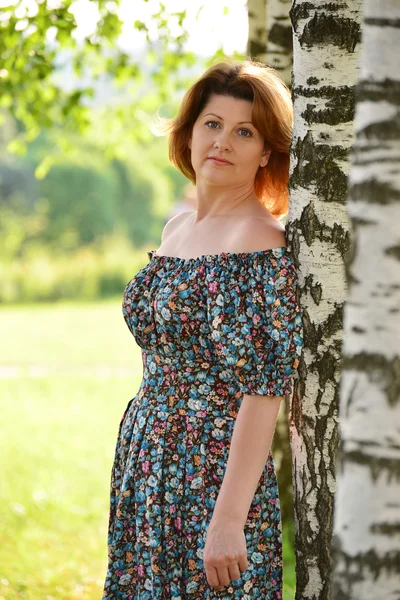 Woman in a dress with open shoulders is about Birch — Stock Photo, Image