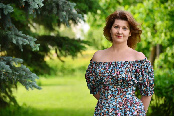 Woman in a dress with open shoulders at  pine forest — Stock Photo, Image