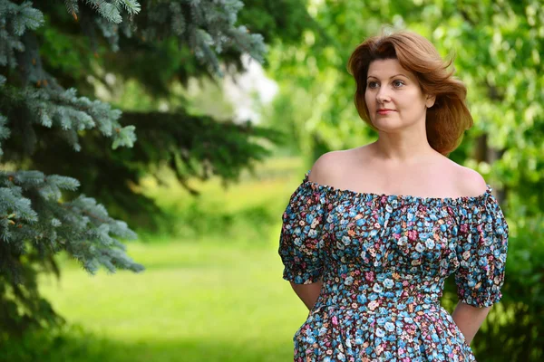 Woman in a dress with open shoulders at  pine forest — Stock Photo, Image