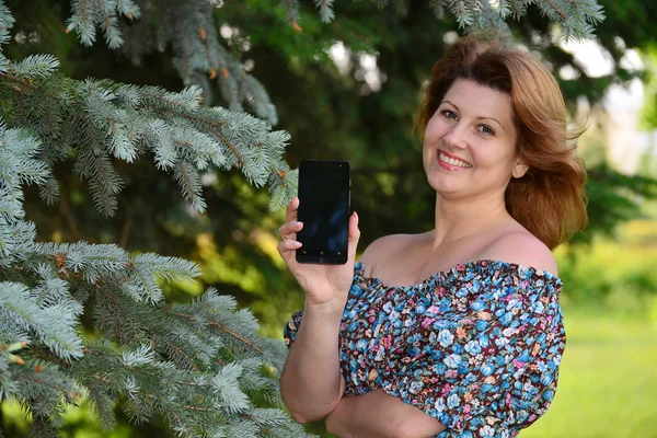 Женщина с мобильным телефоном в Пайн-парке — стоковое фото