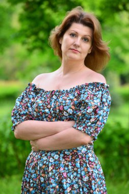 stylish middle-aged woman in the summer park