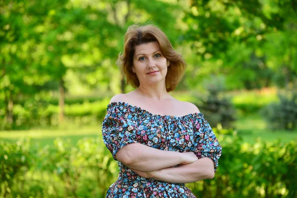 Stylish middle-aged woman in the summer park — Stok fotoğraf