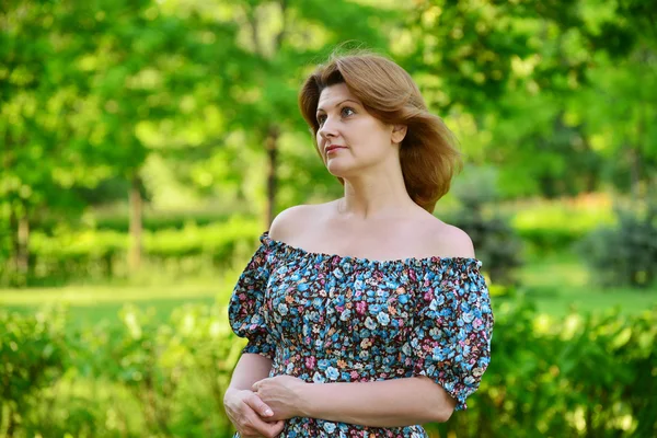 Stylish middle-aged woman in the summer park — Stock Photo, Image