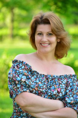 stylish middle-aged woman in the summer park