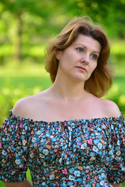 Stylish middle-aged woman in the summer park — Stock Photo, Image