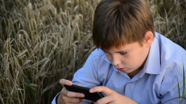 Genç çocuk çayır kırsal kesimde bir akıllı telefon kullanır — Stok video