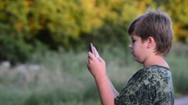 Genç çocuk smartphone açık havada kullanır.