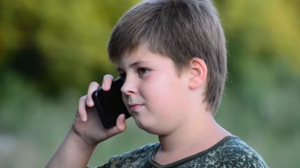 Genç çocuk çayır kırsal kesimde bir akıllı telefon kullanır — Stok video