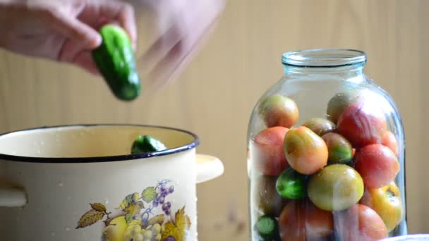 La mujer pone tomates y pepinos en frascos. Inicio enlatado para invierno — Vídeo de stock