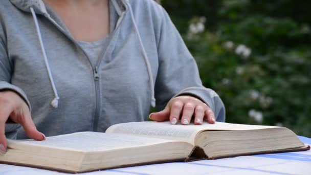 Mujer leyendo un libro en un jardín — Vídeos de Stock