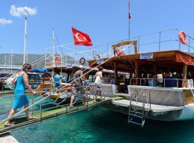 Kemer, Turkey - 06.20.2015. tourists go up the ladder on the boats for excursions in Mediterranean Sea clipart