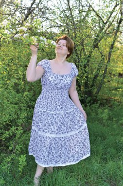 Awoman in  apple orchard at  early spring