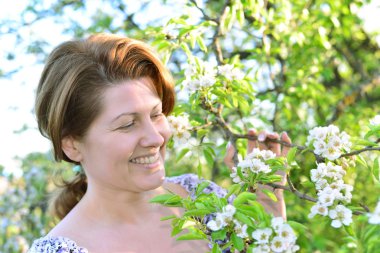 Awoman in  apple orchard at  early spring