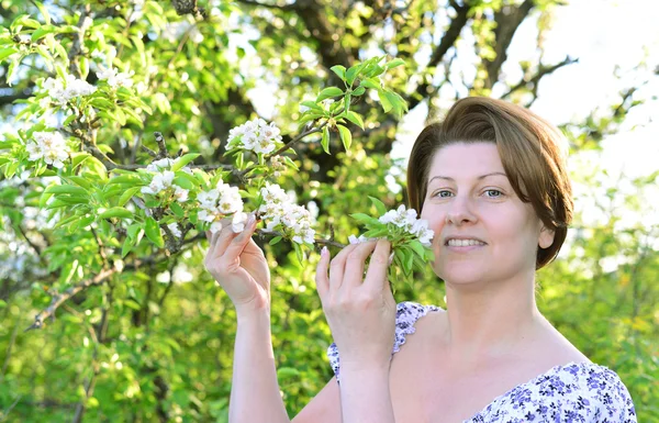 Awoman nel frutteto di mele all'inizio della primavera — Foto Stock