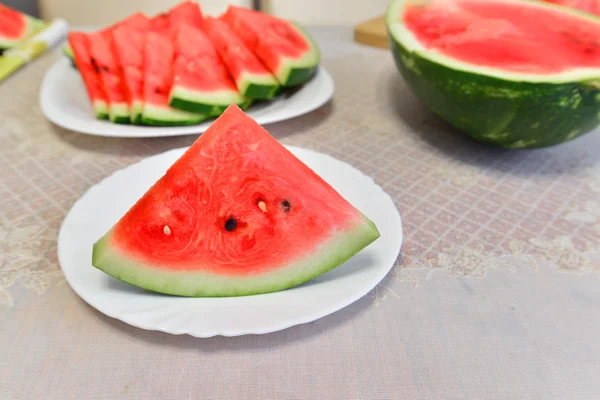 Segmenten van watermeloen op een bord aan de tafel — Stockfoto