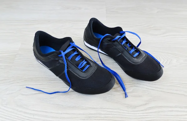 Sneakers with blue laces are on  floor — Stock Photo, Image