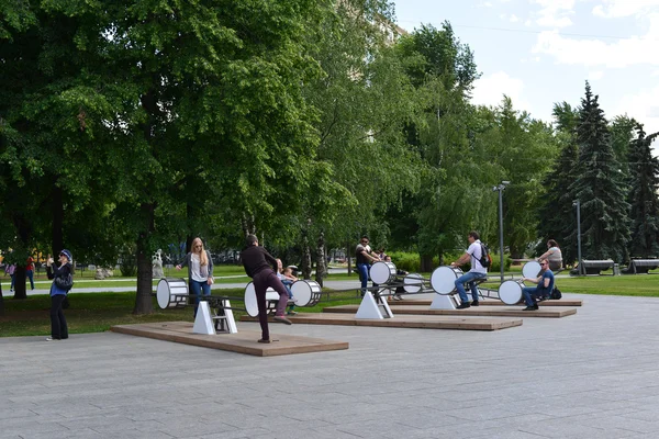 МОСКВА, РОССИЯ -12.06.2015. Люди катаются на качелях в парке Арт Музеон. Парк расположен на площади 23,46 га. — стоковое фото