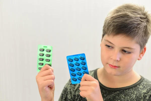 Niño con camisa de camuflaje sosteniendo una droga — Foto de Stock