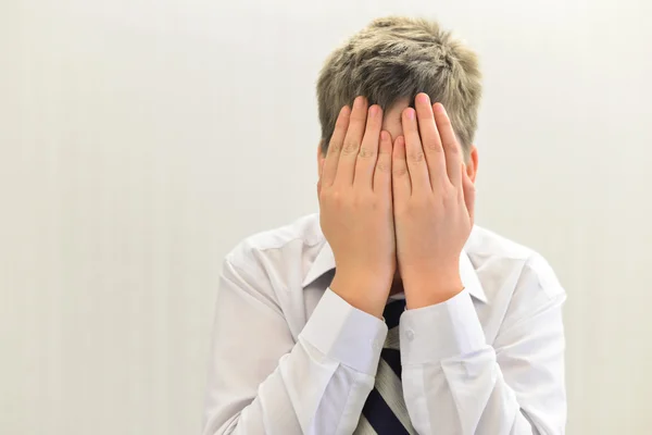 depresif genç çocuk yüzünü elleri ile kaplı.