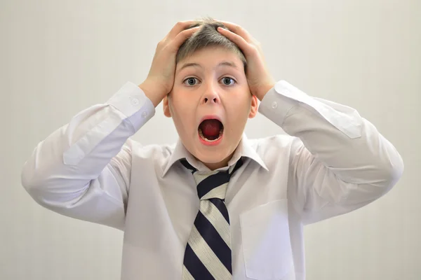 Adolescente niño gritando sosteniendo sus manos detrás de la cabeza —  Fotos de Stock