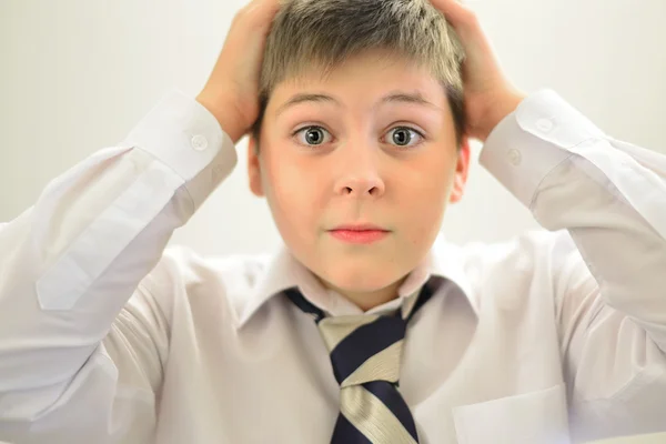 Ragazzo stupito tenendo le mani dietro la testa — Foto Stock